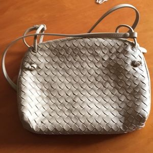 Bottega Veneta purse with shoulder strap, accessories, and storage bag.